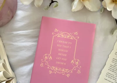 The back cover of the Love & Letter Charms hardback special edition, showing a quote from the book within a decorative frame.