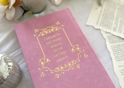 A quote in gold foil on the back cover of the Love & Letter Charms special edition, underneath the dust jacket.